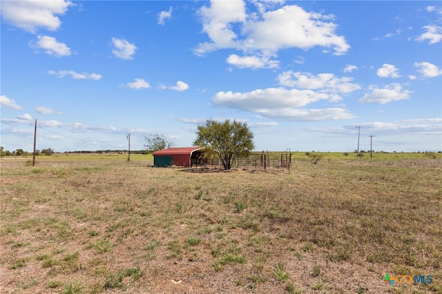 view of yard featuring a rural view and an outdoor structure