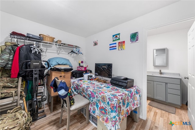 bedroom with light wood-type flooring and sink