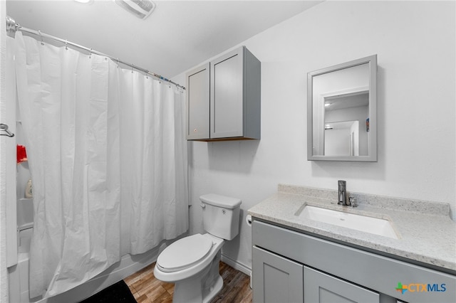 full bathroom with shower / bathtub combination with curtain, wood-type flooring, toilet, and vanity