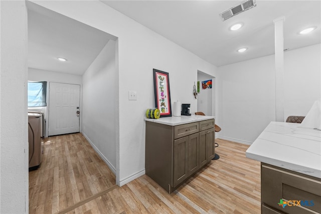 hallway with light wood-type flooring and washer / dryer