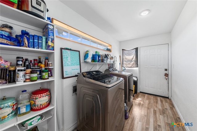 laundry area with washer and dryer and light wood-type flooring