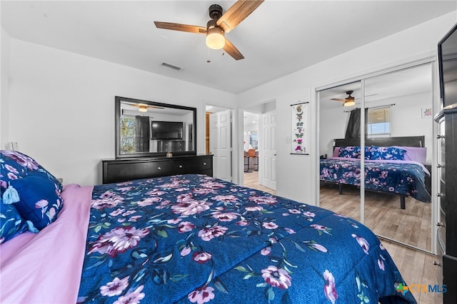 bedroom with a closet, hardwood / wood-style floors, and ceiling fan