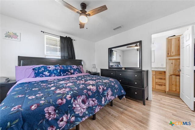 bedroom with ceiling fan, ensuite bath, and light hardwood / wood-style flooring