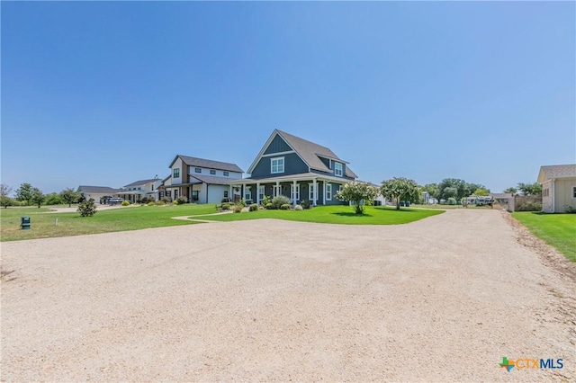 shingle-style home featuring driveway and a front lawn