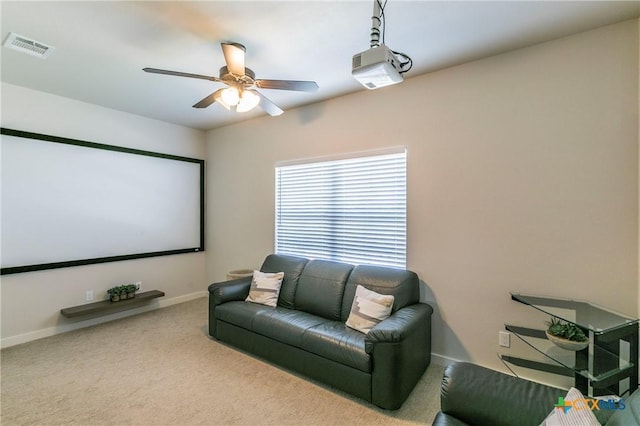 home theater featuring baseboards, carpet floors, visible vents, and a ceiling fan