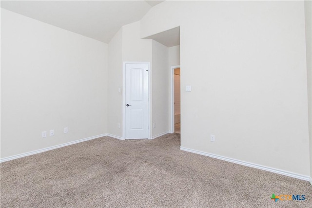 carpeted empty room with vaulted ceiling