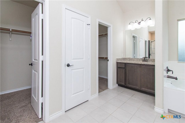 bathroom featuring vanity, tile patterned flooring, and a tub