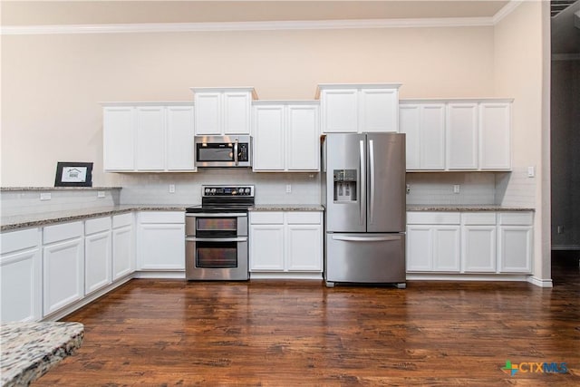 kitchen with appliances with stainless steel finishes, dark wood-type flooring, light stone countertops, white cabinets, and crown molding