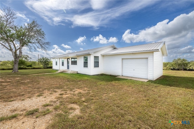 back of house featuring a garage and a lawn