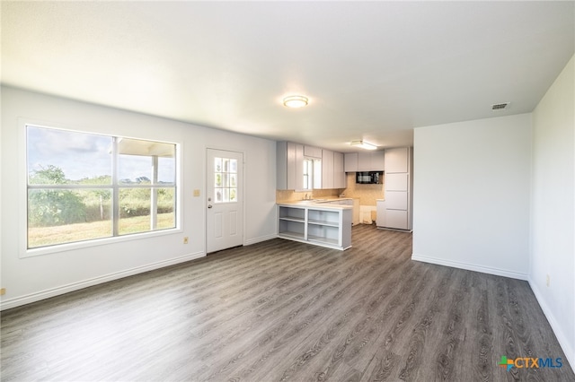 unfurnished living room featuring dark wood-type flooring and sink