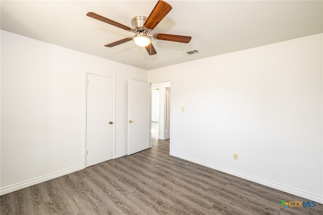 unfurnished bedroom featuring dark wood-type flooring and ceiling fan