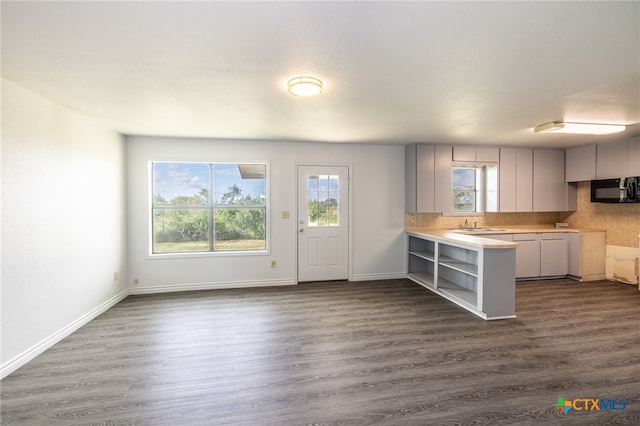 kitchen featuring kitchen peninsula, dark hardwood / wood-style flooring, and gray cabinetry