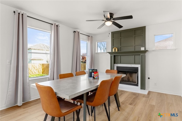 208 Langely, Kyle, TX 78640 - dining space featuring light wood-type flooring, a fireplace, and ceiling fan