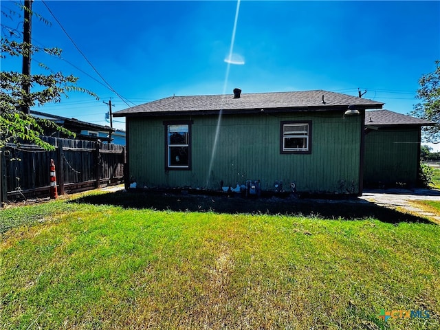 rear view of property featuring a yard