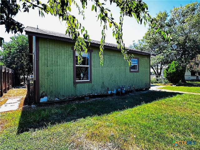 view of side of home with a yard