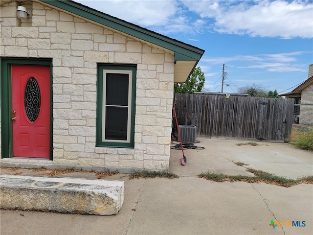 doorway to property with a patio and central AC