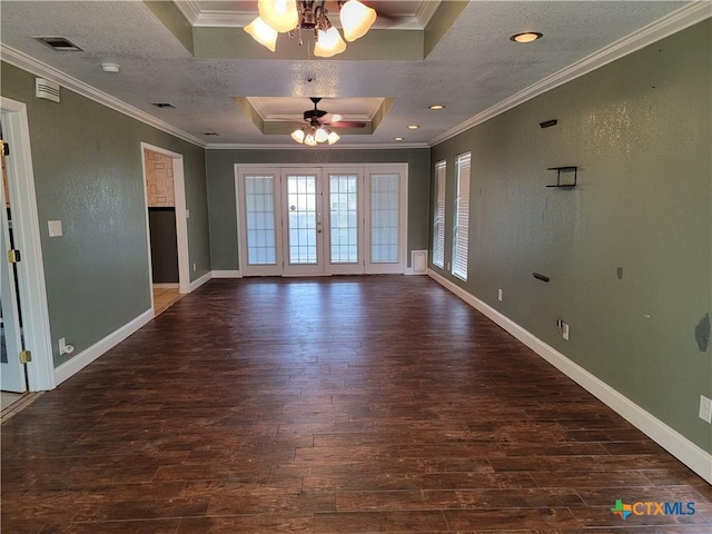 spare room featuring dark hardwood / wood-style floors, a raised ceiling, ceiling fan, and ornamental molding