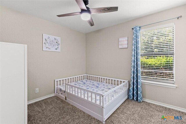 1301 Chapel Creek Rd, Waco, TX 76712 - bedroom with carpet floors, baseboards, a nursery area, and a ceiling fan