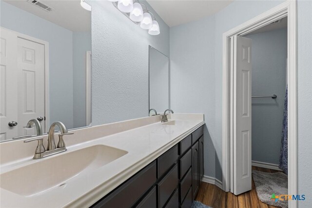 1301 Chapel Creek Rd, Waco, TX 76712 - bathroom with wood finished floors, double vanity, and baseboards