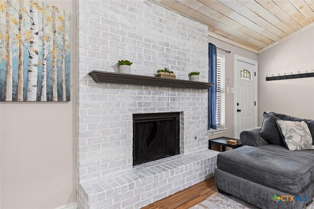 1301 Chapel Creek Rd, Waco, TX 76712 - living area featuring wood finished floors, ornamental molding, wooden ceiling, and a brick fireplace