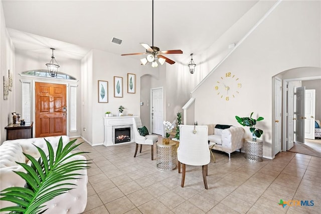 6804 Bayberry Dr, Killeen, TX 76542 - dining area with arched walkways, light tile patterned floors, a ceiling fan, and a lit fireplace