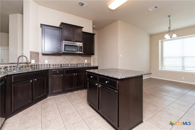 7010 Cokui Dr, Killeen, TX 76542 - kitchen featuring stainless steel microwave, light tile patterned floors, tasteful backsplash, and light stone countertops