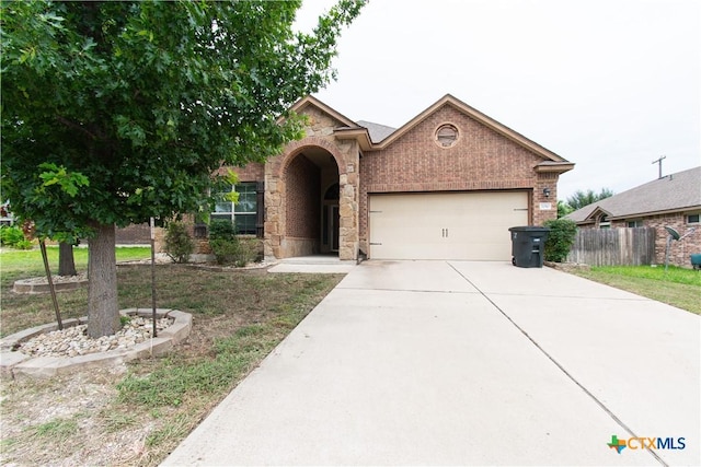 7010 Cokui Dr, Killeen, TX 76542 - view of front of house featuring an attached garage, brick siding, and concrete driveway