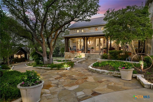 913 Southridge Rd, Salado, TX 76571 - back of house with stone siding, covered porch, and a metal roof