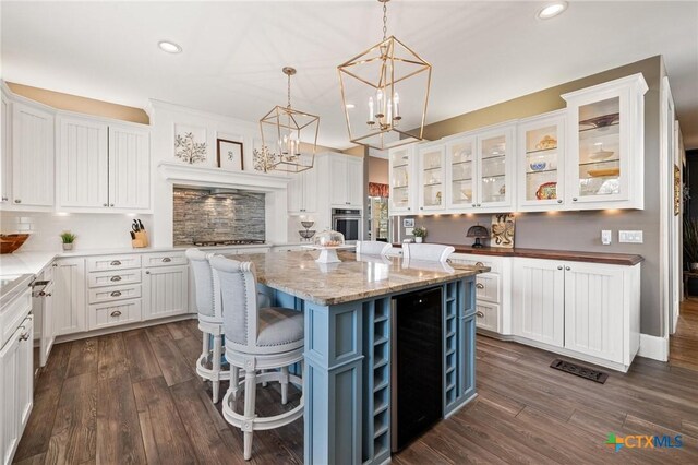 913 Southridge Rd, Salado, TX 76571 - kitchen with stainless steel appliances, white cabinetry, a kitchen island, recessed lighting, and a chandelier