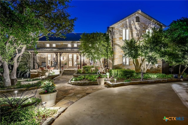 913 Southridge Rd, Salado, TX 76571 - back of house with stone siding, a patio, french doors, a standing seam roof, and a metal roof