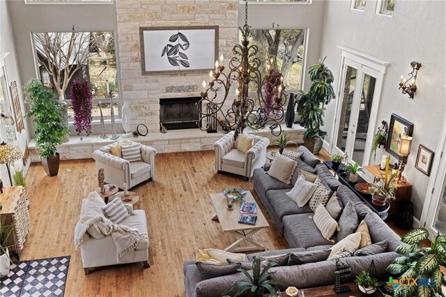 913 Southridge Rd, Salado, TX 76571 - living area featuring a stone fireplace, a towering ceiling, wood finished floors, and healthy amount of natural light