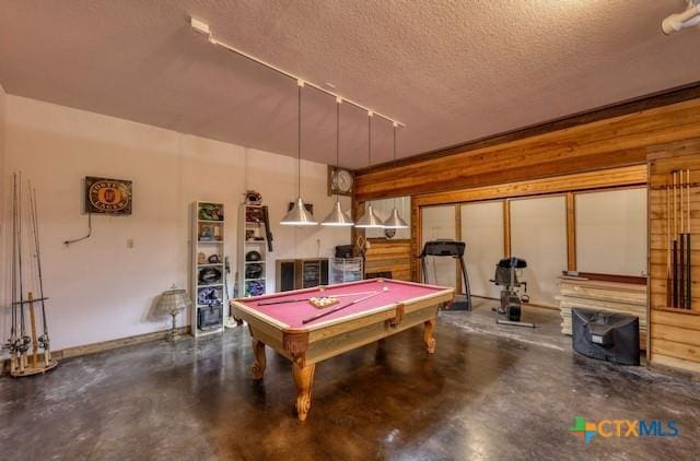 rec room with wooden walls, concrete flooring, a textured ceiling, and pool table