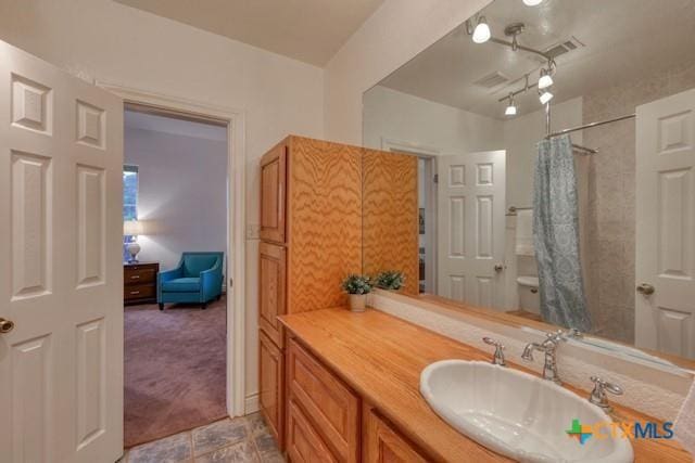 bathroom with vanity, toilet, and curtained shower