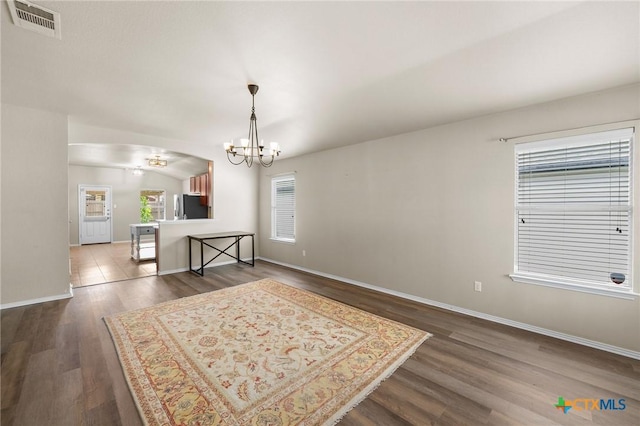 824 Starlight Dr, Temple, TX 76502 - dining area featuring a chandelier, dark wood-style flooring, baseboards, and arched walkways