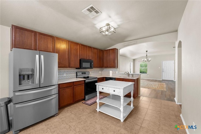 824 Starlight Dr, Temple, TX 76502 - kitchen with black appliances, arched walkways, lofted ceiling, a chandelier, and a peninsula