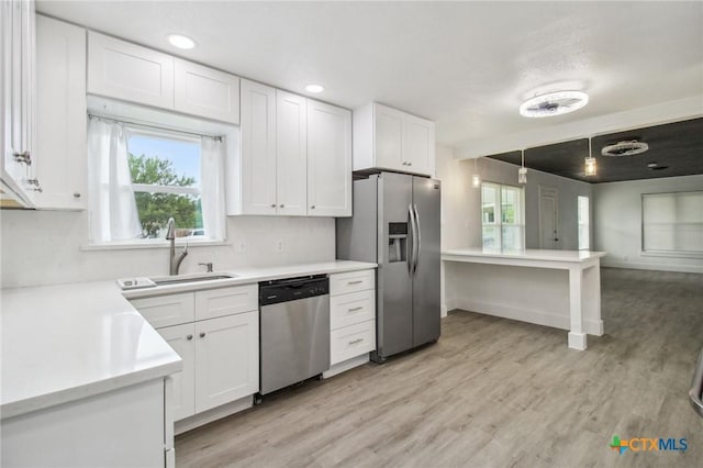 542 Williamsburg Pl, San Antonio, TX 78201 - kitchen with stainless steel appliances, light countertops, white cabinetry, light wood-style floors, and recessed lighting