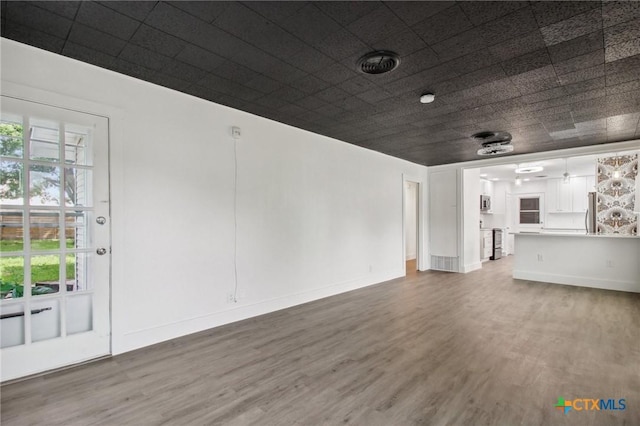 542 Williamsburg Pl, San Antonio, TX 78201 - unfurnished living room featuring wood finished floors, plenty of natural light, and baseboards