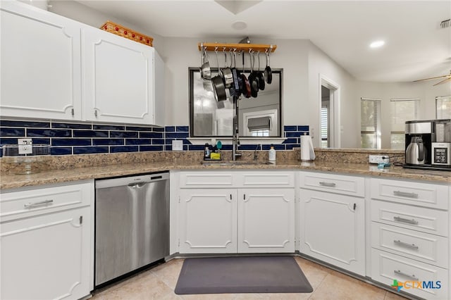 1207 Old Homestead, Seguin, TX 78155 - kitchen featuring stainless steel dishwasher, white cabinets, light tile patterned floors, tasteful backsplash, and light stone countertops