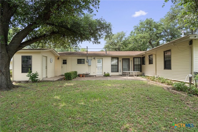 back of property with a patio and a lawn