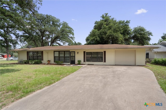 single story home featuring a garage and a front yard