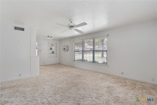 carpeted empty room featuring a textured ceiling and ceiling fan