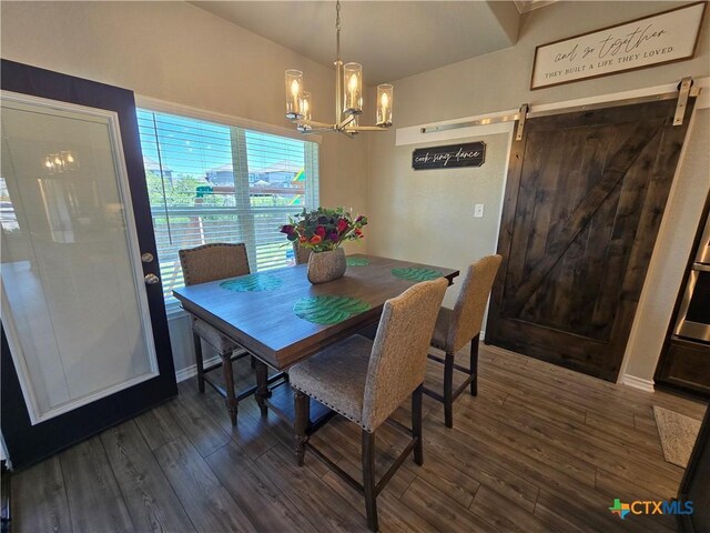 dining space with a barn door, dark wood-style flooring, and a notable chandelier