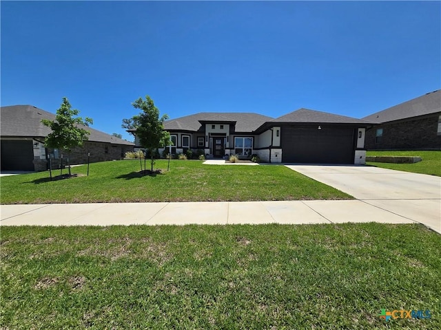 prairie-style house featuring driveway, a front yard, and a garage
