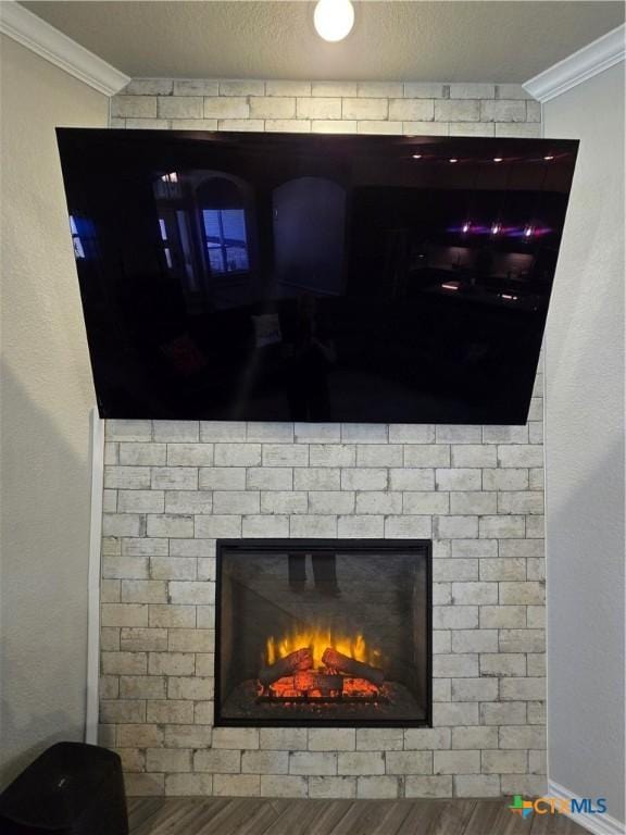 detailed view of ornamental molding, baseboards, and a brick fireplace