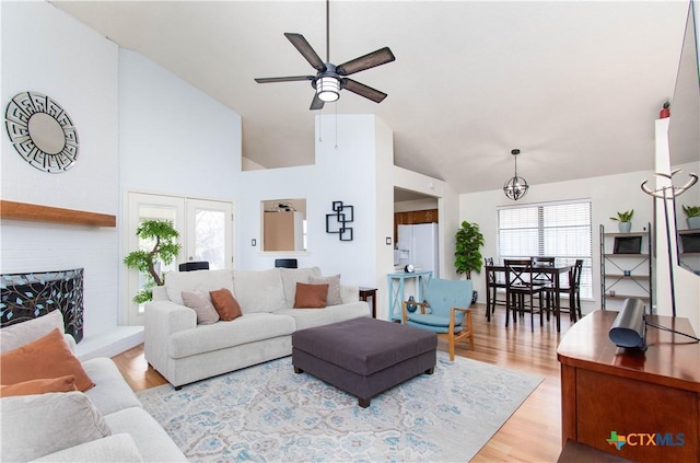 living area featuring high vaulted ceiling, wood finished floors, and a ceiling fan