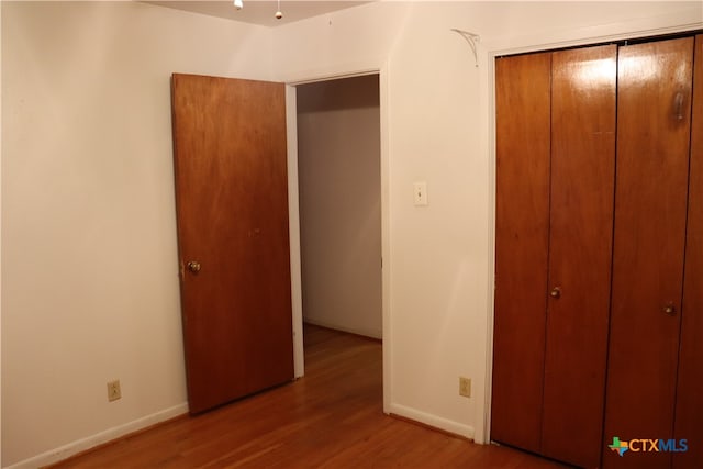 unfurnished bedroom with light hardwood / wood-style flooring and a closet