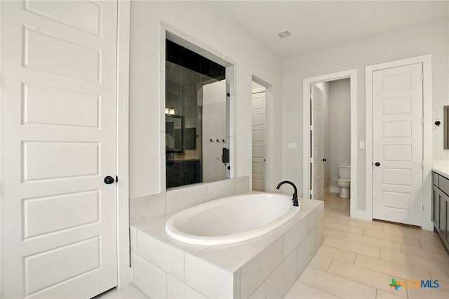 1911 Peres St, New Braunfels, TX 78132 - bathroom with vanity, a garden tub, toilet, and tile patterned floors