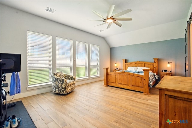 1911 Peres St, New Braunfels, TX 78132 - bedroom with light wood-style flooring, a barn door, vaulted ceiling, ceiling fan, and baseboards