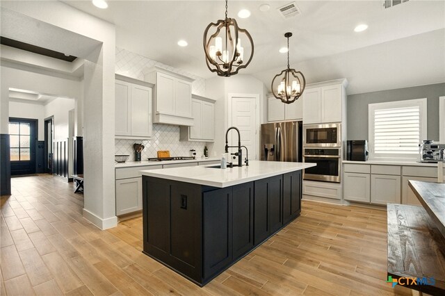1911 Peres St, New Braunfels, TX 78132 - kitchen with appliances with stainless steel finishes, a chandelier, a sink, backsplash, and light countertops