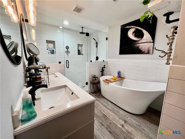108 Elaine St, Victoria, TX 77904 - full bathroom with a sink, wood finished floors, a stall shower, tile walls, and double vanity